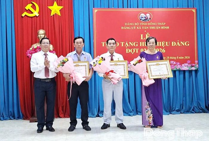 Đồng chí Trần Thanh Nguyên trao Huy hiệu Đảng cho các đảng viên.