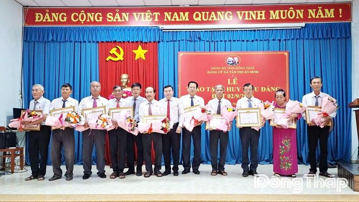 Đồng chí Võ Hữu Tốt, Bí thư Đảng ủy, Chủ tịch HĐND xã, trao Huy hiệu Đảng cho các đảng viên.