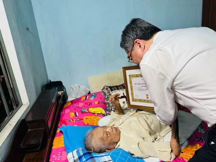  Đồng chí Nguyễn Thanh Nghị trao tặng Huy hiệu 80 năm tuổi Đảng cho đảng viên lão thành Huỳnh Thị Cạnh (SN 1931) ở tổ dân phố 5, phường Quy Nhơn. Ảnh: N.H 