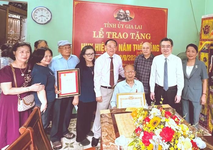  Đồng chí Nguyễn Thanh Nghị (thứ 2 từ phải sang) và đồng chí Thái Đại Ngọc (thứ 5 từ phải sang) chụp ảnh lưu niệm cùng đảng viên lão thành Phan Ngọc Bích và gia đình. Ảnh: N.H 
