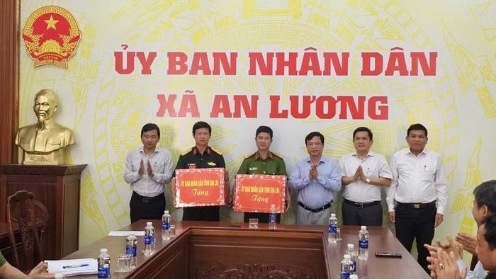 Phó Chủ tịch Thường trực UBND tỉnh Nguyễn Tuấn Thanh (thứ 3 từ phải sang) tặng quà cho Ban Chỉ huy Quân sự và Công an xã An Lương. Ảnh: Phi Long