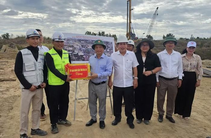 Phó Chủ tịch Thường trực UBND tỉnh Nguyễn Tuấn Thanh (thứ 5 từ phải sang) tặng quà cho công nhân thi công Dự án tuyến đường từ QL 19C kết nối cảng Quy Nhơn. Ảnh: Phi Long