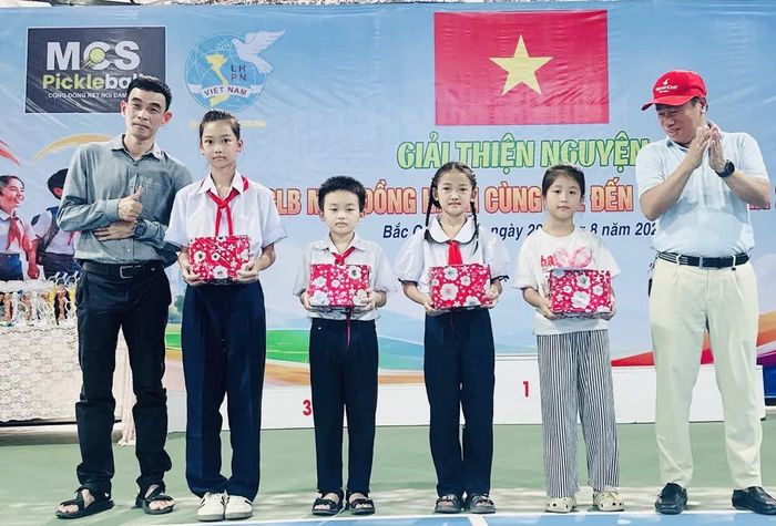 Các mạnh thường quân trao quà cho học sinh.