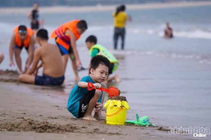 Em bé nghịch cát bãi biển.