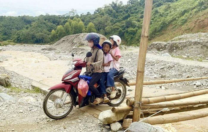 Phụ huynh chở hai con qua cầu tạm Nà Lặc về nhà vào chiều 28/8/2026.