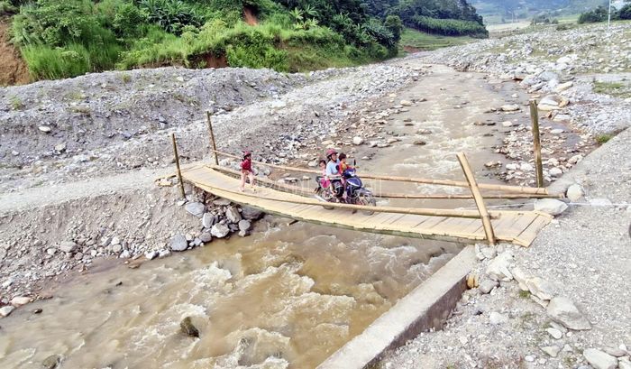 Dù đã có cầu tạm qua suối Nà Lặc, việc đưa đón học sinh qua đây vẫn gặp nhiều khó khăn.