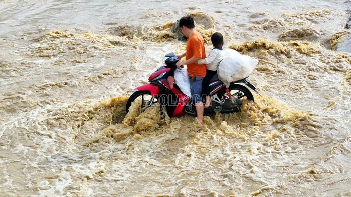 Người dân chở con qua suối nhưng xe bị chết máy giữa dòng nước.