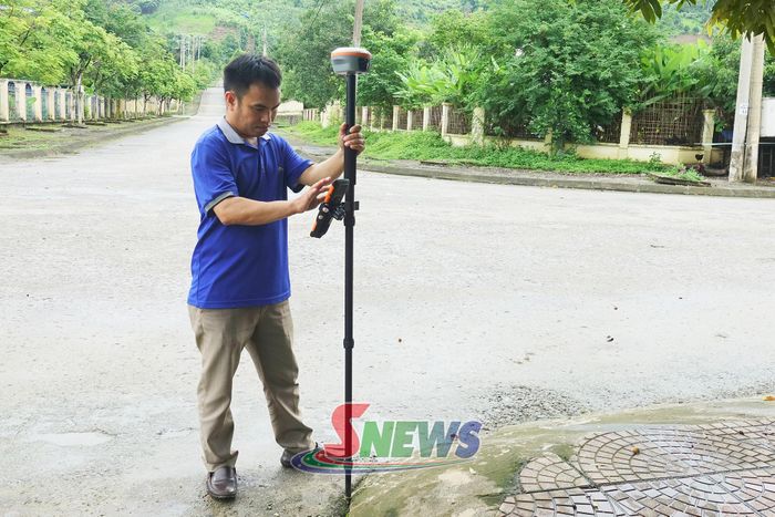 Cán bộ Văn phòng Đăng ký đất đai khu vực I đo đạc, xác minh hiện trạng thửa đất tại xã Quỳnh Nhai.