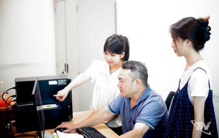 Họa sĩ Quang Duy (giữa), Phòng Báo in - Báo điện tử, hướng dẫn sinh viên Trường Đại học Công nghệ thông tin và Truyền thông (Đại học Thái Nguyên) dàn trang, thiết kế đồ họa cho các sản phẩm báo chí đa phương tiện. Ảnh: QK