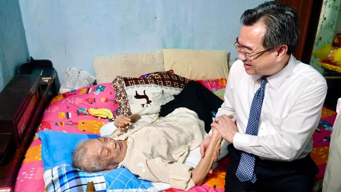 Đồng chí Nguyễn Thanh Nghị ân cần hỏi thăm sức khoẻ đảng viên Huỳnh Thị Cạnh.