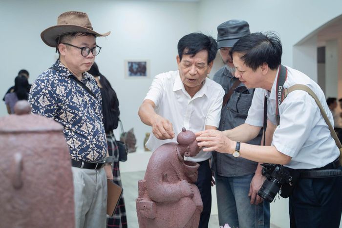Nhà điêu khắc Nguyễn Lưu (thứ 2 từ trái sang) giới thiệu với khách mời về tác phẩm của mình tại không gian triển lãm.
