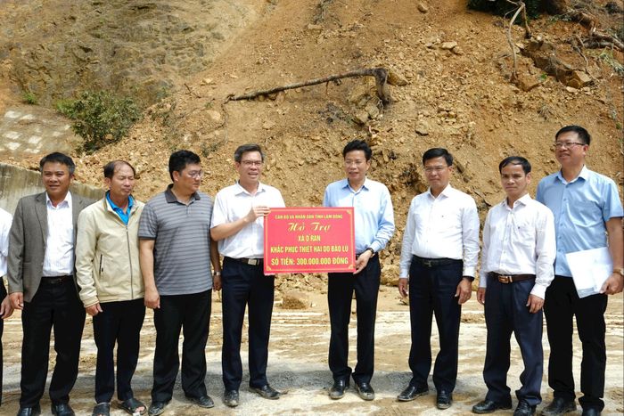 Phó Bí thư Tỉnh ủy, Chủ tịch HĐND tỉnh Lưu Văn Trung cùng đoàn công tác trao tặng số tiền hỗ trợ 300 triệu đồng cho xã D'ran khắc phục thiệt hại do mưa lũ gây ra. Ảnh: Hoàng Sa