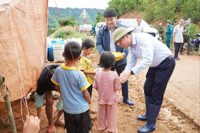 Phó Bí thư Tỉnh ủy, Chủ tịch HĐND tỉnh Lưu Văn Trung tặng quà cho các cháu đi tránh lũ cùng gia đình trong chuyến khảo sát tình hình ngập lụt, sạt lở tại xã Quảng Phú. Ảnh: Hoàng Hoài