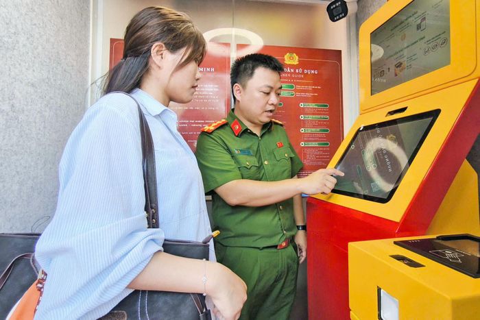 Cán bộ chiến sĩ hướng dẫn người dân trải nghiệm tại Kiosk "Trạm Cảnh sát thông minh". Ảnh: Trung Kiên