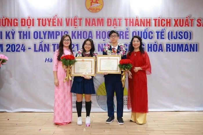 Vương Hà Chi và Vũ Nhật Long chụp ảnh cùng Ban lãnh đạo nhà trường trong Lễ tuyên dương học sinh đạt thành tích Kỳ thi Olympic Khoa học trẻ quốc tế IJSO 2024. Ảnh: NTCC