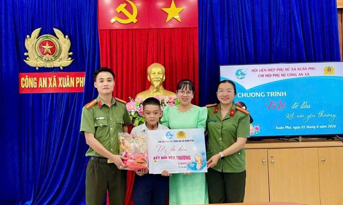 Cán bộ Công an xã Xuân Phú trao quà tặng học sinh nghèo hiếu học trong chương trình “Mẹ đỡ đầu”.