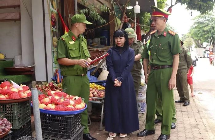 Công an phường Mộc Sơn tuyên truyền cho các hộ kinh doanh chấp hành quy định về hành lang ATGT.