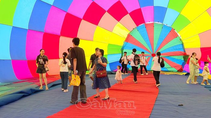 Du khách và người dân chụp ảnh bên trong khinh khí cầu.