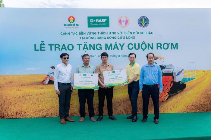 Đại diện các HTX nhận máy cuộn rơm từ chương trình. Ảnh: Phân bón Cà Mau