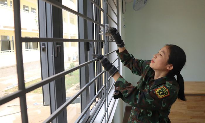 Cán bộ, chiến sĩ lau chùi cửa kính.