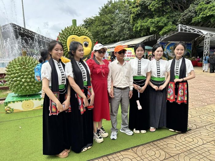 Những thiếu nữ mang sắc phục dân tộc Thái cùng chụp ảnh lưu nhiệm với người dân tham dự lễ hội.