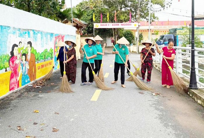 Người dân thôn Vạn Thắng 2 (xã Cổ Đô) tham gia vệ sinh môi trường. Ảnh: Lê Thêm