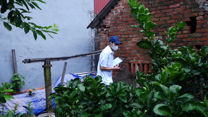 Ông Phạm Đình Việt kiểm tra từng khu vực quanh nhà dân, chủ động tìm và loại bỏ những nơi có nguy cơ phát sinh bọ gậy. Ảnh: Đỗ Duẩn