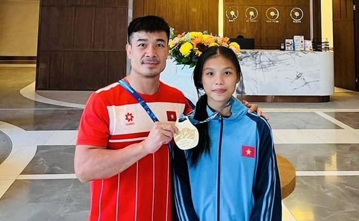 HLV Nguyễn Thế Anh của đội tuyển vật bãi biển trẻ Việt Nam và đô vật Lò Thị Hồng sau khi vô địch hạng 45kg nữ giải vật bãi biển trẻ thế giới 2026. Ảnh: Nguyễn Thế