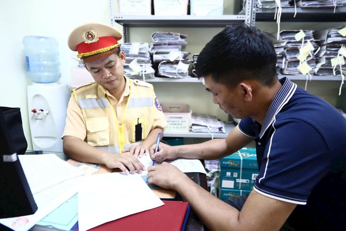 Lực lượng CSGT lập biên bản xử lý tài xế xe khách vi phạm quy định về vận tải hành khách. Ảnh: VT