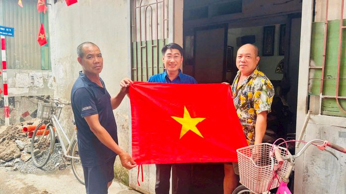 Người dân Thuý Lĩnh, phường Lĩnh Nam, hân hoan treo cờ Tổ quốc mừng Quốc khánh 2-9. Ảnh: PV