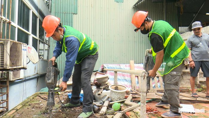 Lực lượng chức năng hỗ trợ gia đình bà Nguyễn Thị Thanh Vân, số nhà 2A, tập thể Trại Nhãn. Ảnh: Lại Tấn