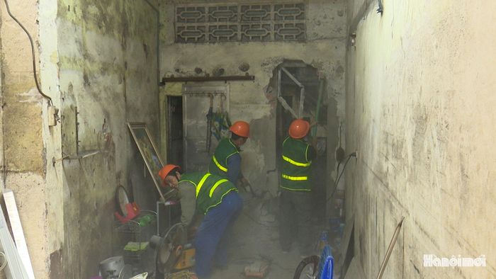 Lực lượng chức năng hỗ trợ gia đình ông Bạch Đăng Hà tháo dỡ, di chuyển tài sản. Ảnh: Lại Tấn
