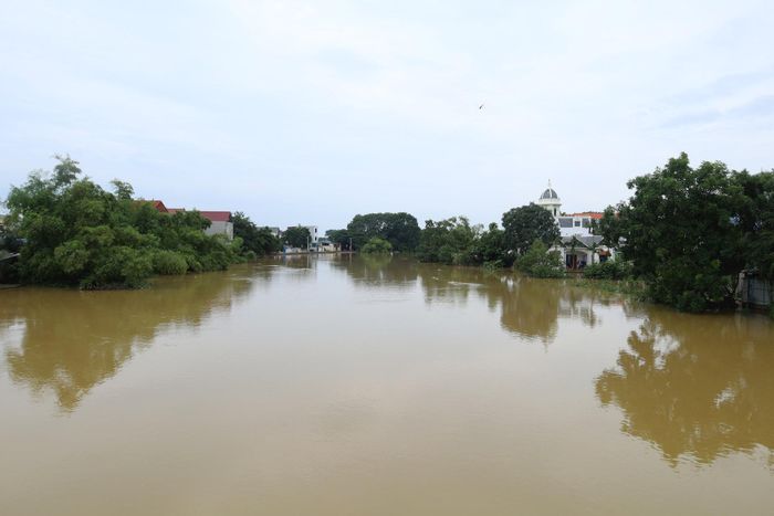 Lũ sông Bùi đang xuống nhưng tốc độ chậm và ở mức cao, tiếp tục gây ngập lụt một số khu dân cư ven sông. Ảnh: Bảo Châu