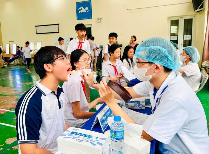 Bác sĩ khám răng-hàm-mặt cho học sinh Trường THCS Thịnh Liệt. Ảnh: Trần Oanh.