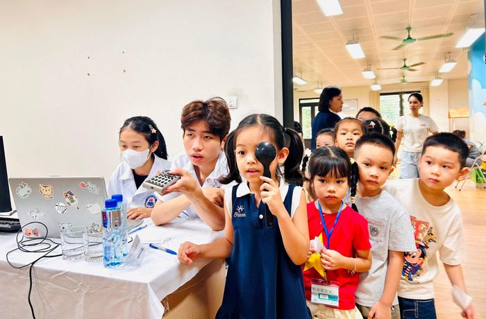 Các em học sinh Trường Tiểu học Tam Trinh được y bác sĩ kiểm tra thị lực. Ảnh: Trần Oanh.