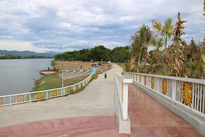 Từ phía cầu Nguyễn Hoàng nhìn xuống, các tuyến đường dạo uốn cong men theo sườn công viên, trong khi khu vực sân khấu ven sông và những mảng cây xanh tạo nên diện mạo ngày càng rõ nét cho không gian này. Ảnh: H.D.