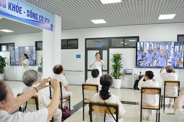 Nhân viên y tế hướng dẫn các cụ tập luyện. Ảnh: Tuấn Anh