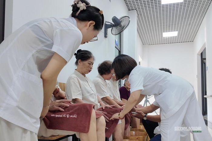 Nhân viên hỗ trợ người cao tuổi trong giờ chăm sóc. Ảnh: Tuấn Anh