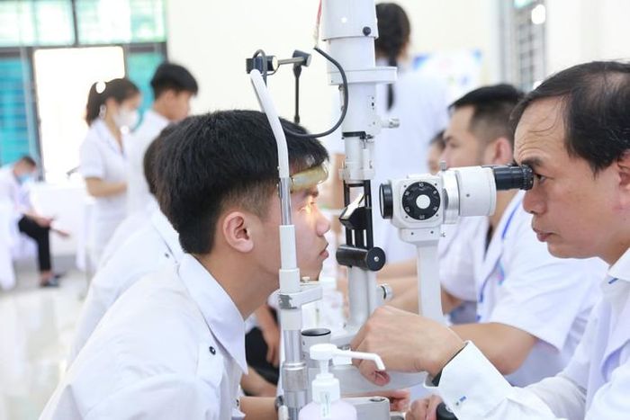 Bác sĩ khám mắt, kiểm tra thị lực cho học sinh trong chương trình khám sức khỏe. ẢNH: V. Đồng