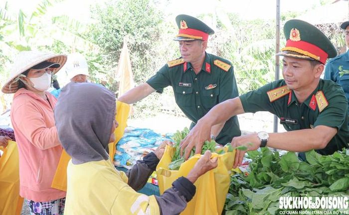 Lực lượng vũ trang phường Ba Ngòi ân cần trao những bó rau cho bà con. Ảnh: Duy Ngọc.