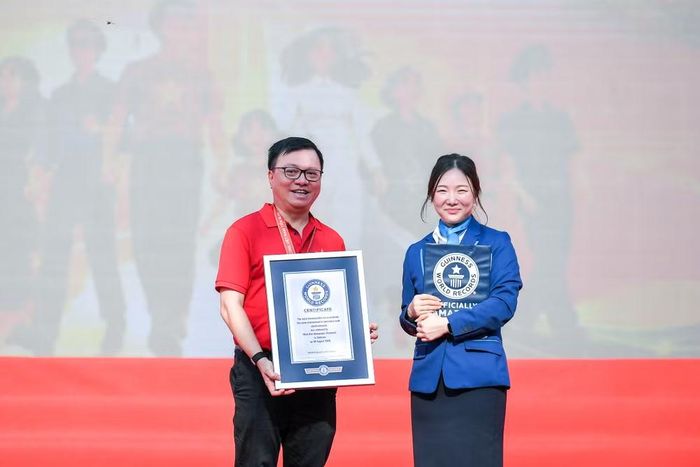 Đồng chí Lê Quốc Minh, Ủy viên Trung ương Đảng, Tổng Biên tập Báo Nhân Dân, Phó Trưởng ban Tuyên giáo Trung ương, Chủ tịch Hội Nhà báo Việt Nam thay mặt Ban tổ chức nhận chứng nhận Kỷ lục Guinness thế giới từ bà Sohn Minyoung, Giám khảo chính thức của Guinness World Records, đại diện Tổ chức Kỷ lục Guinness thế giới