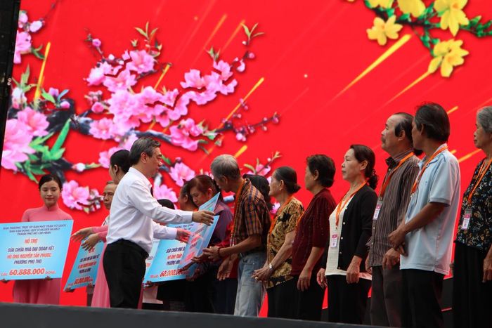 Ông Nguyễn Phước Lộc - Ủy viên Trung ương Đảng, Phó Bí thư Thành ủy, Chủ tịch Ủy ban MTTQ Việt Nam TPHCM trao bảng tượng trưng hỗ trợ kinh phí cho các hộ có hoàn cảnh khó khăn sửa nhà Đại đoàn kết. Ảnh: Q.Đ.