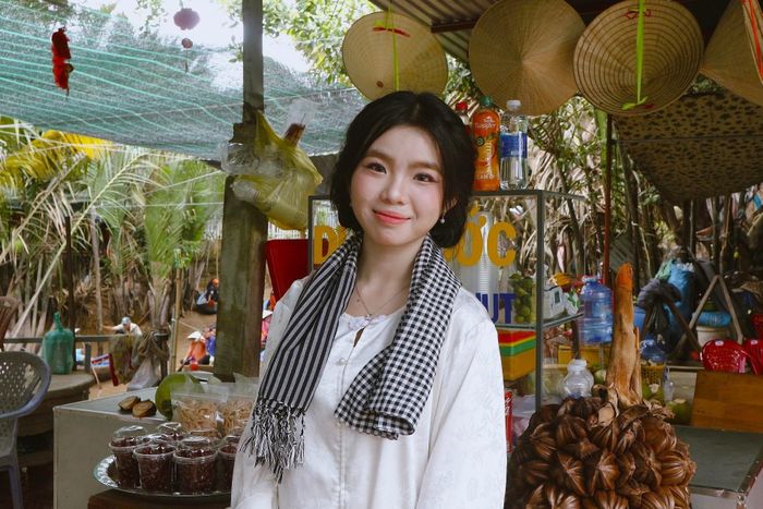  Ngọc Mai chọn bà ba trắng, choàng khăn rằn để chụp ảnh cùng xuồng ba lá. Ảnh: Trúc Hồ. 