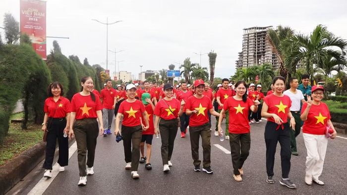Không khí dịu mát làm cho buổi đi bộ càng thêm thuận lợi, ai cũng rạng rỡ trong áo cờ đỏ sao vàng. (Ảnh: HƯƠNG GIANG)