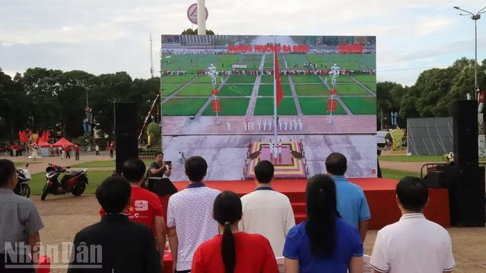 Các đại biểu và nhân dân cùng hướng về Quảng trường Ba Đình, Hà Nội theo dõi Lễ thượng cờ. (Ảnh: Công Lý)