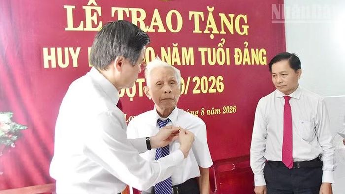 Đồng chí Phạm Thành Nối (giữa), Chi bộ Khóm 1, Đảng bộ phường Hòa Thuận, tỉnh Vĩnh Long nhận Huy hiệu 80 năm tuổi Đảng. (Ảnh: MINH KHỞI)