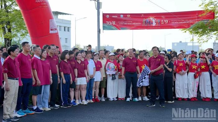 Phó Bí thư Thường trực Tỉnh ủy Cà Mau Huỳnh Quốc Việt cầm cờ hiệu phát lệnh xuất phát. (Ảnh: HỮU TÙNG)