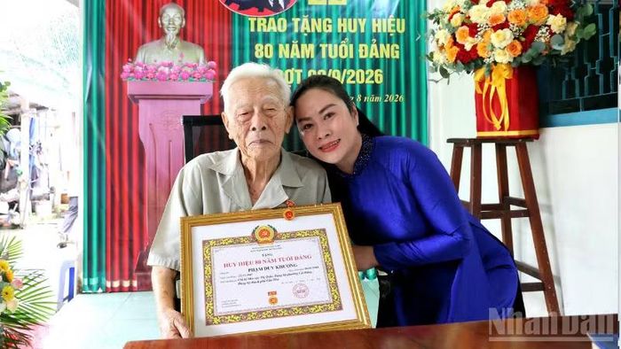 Ông Phạm Duy Khương chụp hình lưu niệm với cháu nội. (Ảnh: VĂN ÚT)
