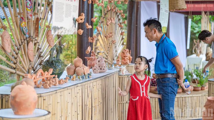 Một góc trưng bày các sản phẩm gốm đất nung mộc mạc thu hút sự chú ý của em nhỏ và gia đình. Những tác phẩm thủ công không chỉ là vật trang trí mà còn là hiện thân của văn hóa bản địa được trao truyền qua nhiều thế hệ đang kể câu chuyện của riêng mình.