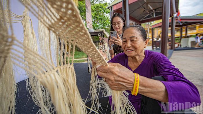 Tại góc "Chạm truyền thống", du khách được tận mắt chiêm ngưỡng đôi bàn tay tài hoa của nghệ nhân đang tỉ mỉ đan chiếc võng bằng sợi ngô đồng.